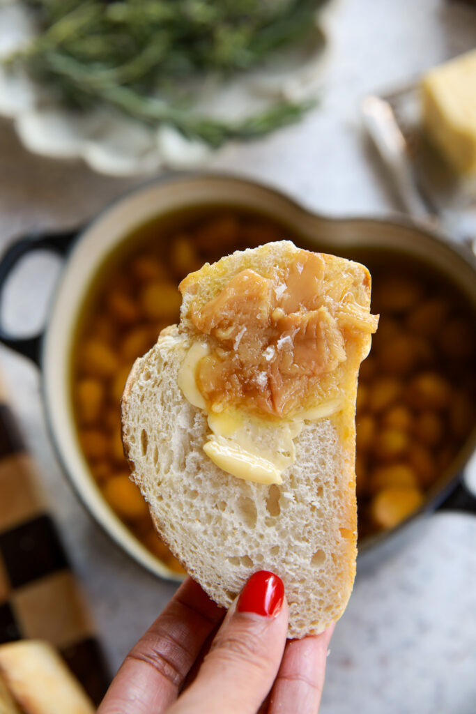 A slice of toasted bread topped with soft garlic confit and golden olive oil.