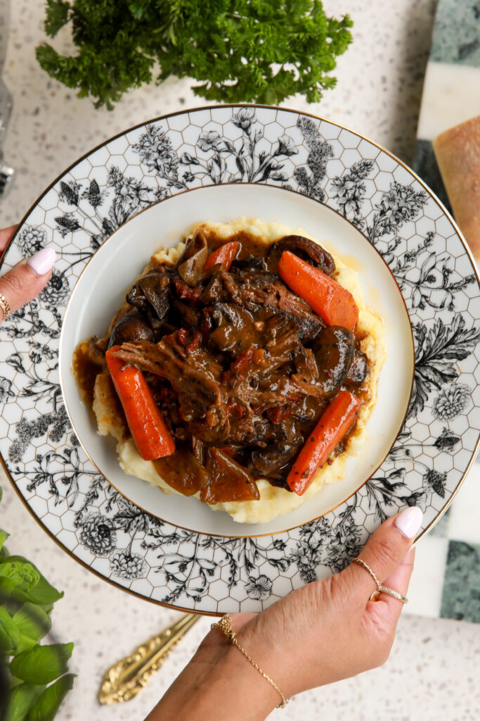 Slow cooked chuck roast surrounded by carrots and mushrooms in a rich savory gravy.
