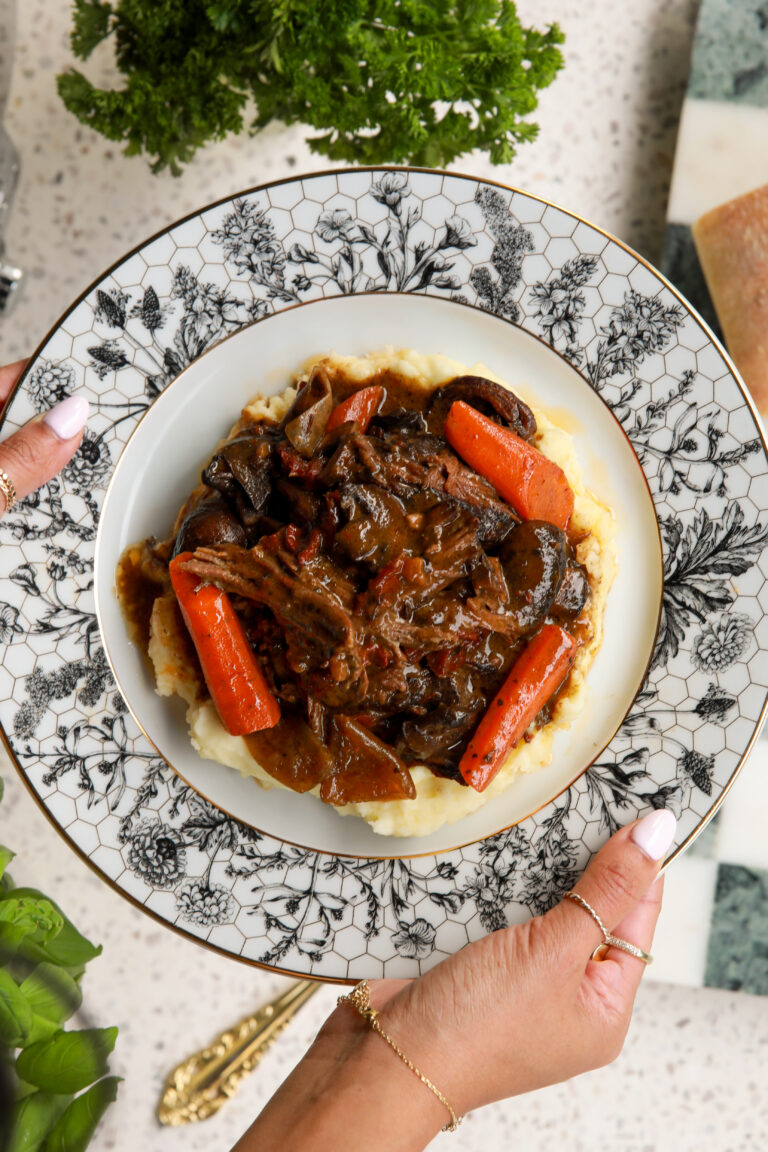 Slow cooked chuck roast surrounded by carrots and mushrooms in a rich savory gravy.