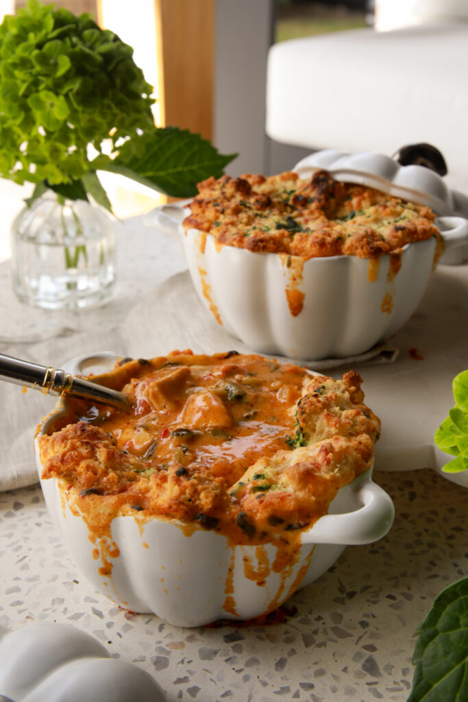 Creamy Marry Me Chicken Pot Pie Soup in white ramekins topped with golden cheddar bay biscuits