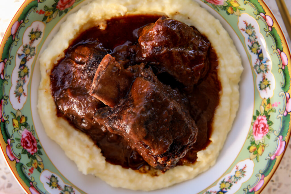 red wine short braised ribs over creamy mashed potatoes in a bowl