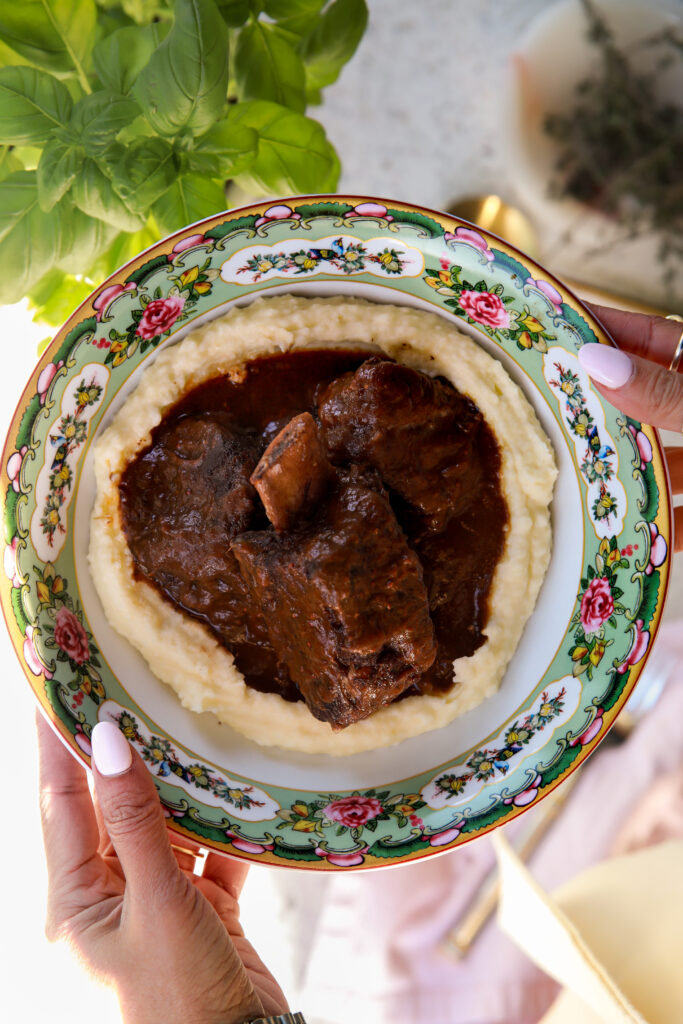 red wine braised short braised ribs over creamy mashed potatoes in a bowl