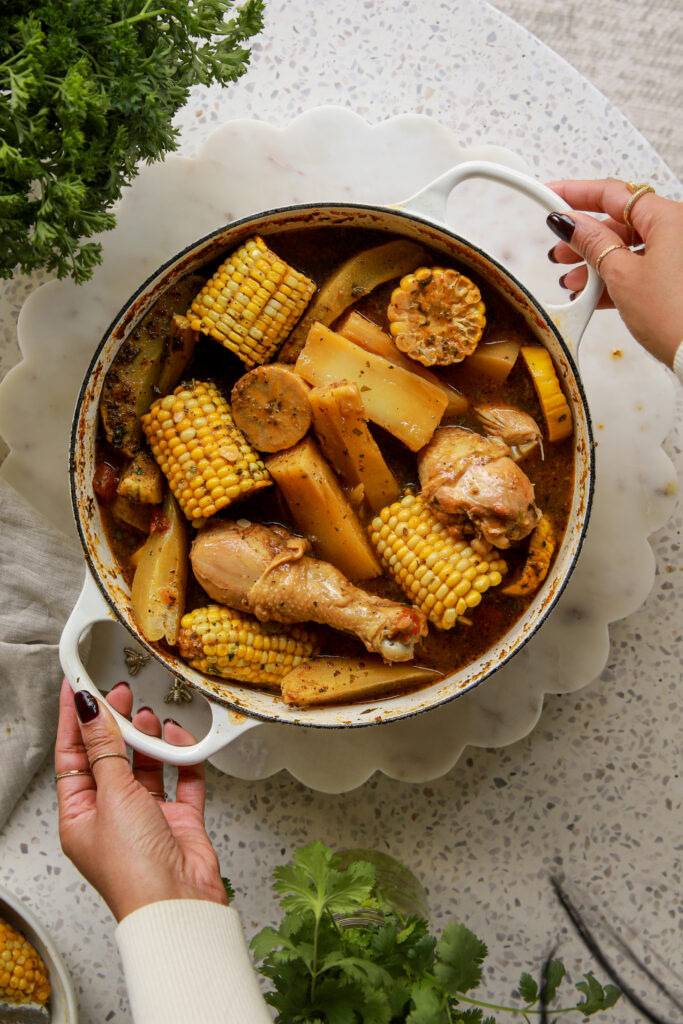 Panamanian caldo de pollo served in a bowl with bone-in chicken, yuca, corn, green plantain, and fresh cilantro