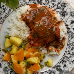 creamy coconut chicken and rice served on a plate with fluffy white rice and rich coconut gravy