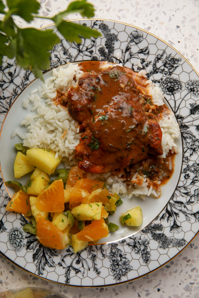 creamy coconut chicken and rice served on a plate with fluffy white rice and rich coconut gravy
