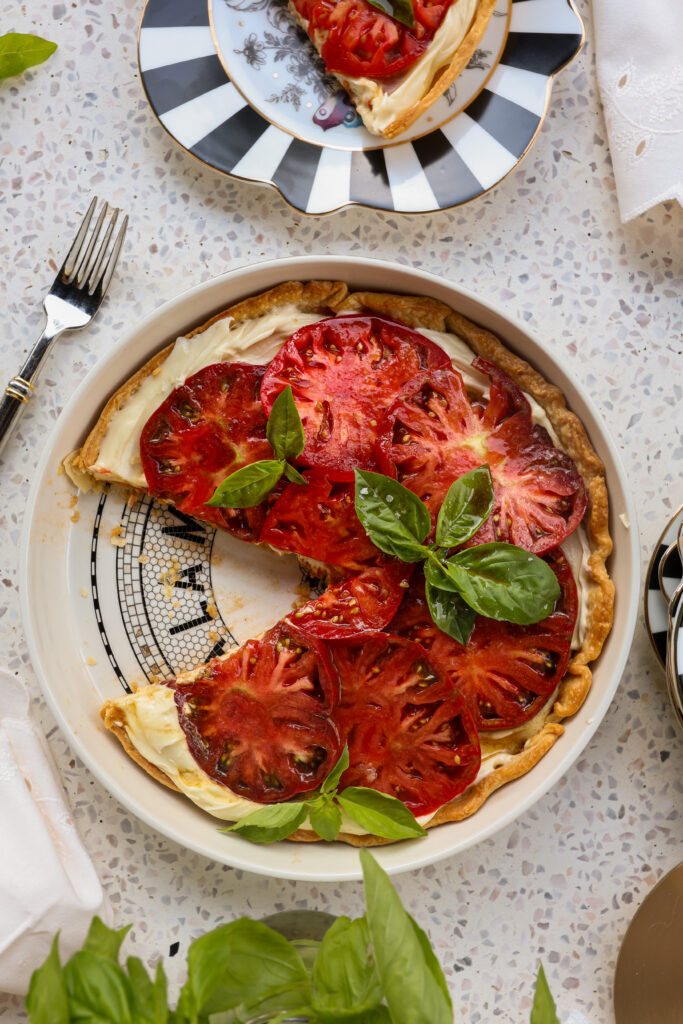 Slice of whipped Brie heirloom tomato tart served on a pie plate