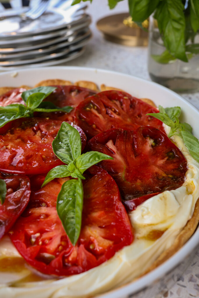 Close-up of whipped Brie heirloom tomato tart with basil garnish